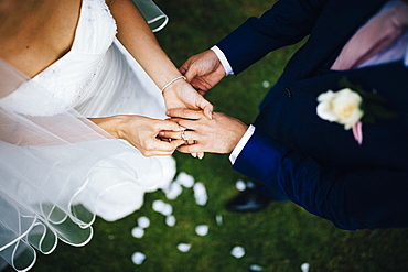 High angle view of husband and wife exchange vows and rings during their wedding ceremony, Thailand