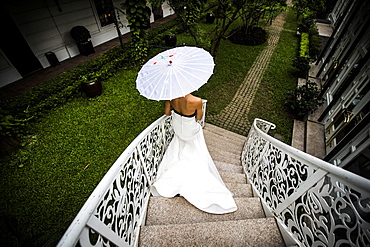 High angle view of young bride walking down an ornate staircase, Vietnam