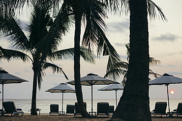 Beachside umbrellas at a luxury resort on a tropical island at sunset, Vietnam