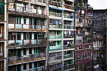 Facade of rows of run down apartment houses with washing hanging on balconies, Myanmar