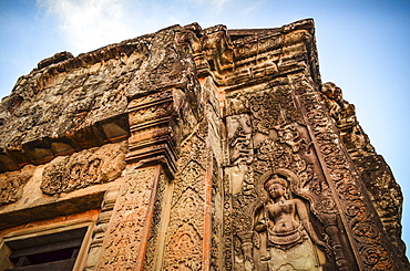 Ankor Wat, a 12th century historic Khmer temple and UNESCO world heritage site. Arches and carved stone with large roots spreading across the stonework, Angkor Wat, Cambodia