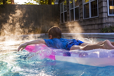 A young boy playing in pool at sunrise, St Simon's Island, Georgia, United States