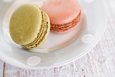 High angle close up of two macaroons on a white plate, United Kingdom