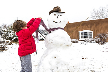 A young boy building a snowman, United States