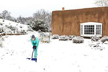 A teenage girl building a snowman, United States