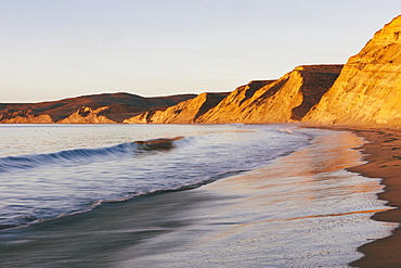 Steep cliffs and beach with surf at dawn, Marin County, California, United States