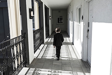 A six year old boy walking down corridor