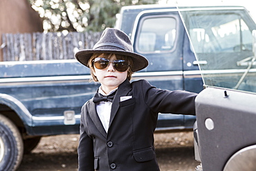 Six year old boy leaning on car open car door