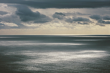 Storm clouds clearing over expansive ocean, dappled sunlight on the water, Oregon, United States of America