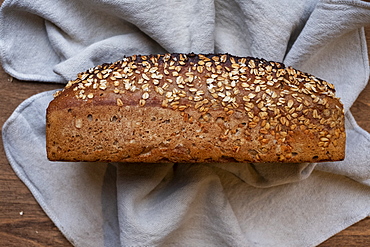 High angle close up of freshly baked seeded loaf of bread in an artisan bakery.