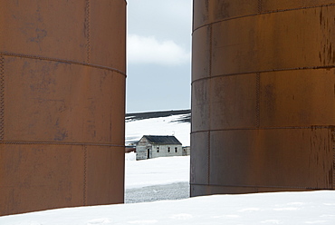 The tall sides of rusting metal whale oil tanks at the former whaling station on Deception Island, Deception Island, South Shetland Islands, Antarctica