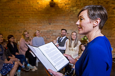 Celebrant performing naming ceremony for parents and their baby daughter in an historic barn