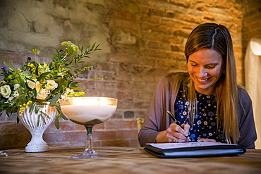 Witness signing certificate during naming ceremony in an historic barn