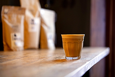 Close up of glass of cafe latte on a rustic wooden table in a cafe