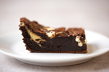 Close up of chocolate cheesecake on white plate in a cafe