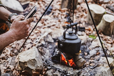High angle close up of kettle over camp fire in a forest, Devon, United Kingdom