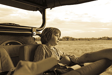 Five year old boy seated in a safari vehicle, monochrome, Moremi Game Reserve, Botswana