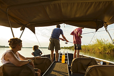 A group of tourists, family fishing from a boat on the Zambezi River, Botswana, Zambezi River, Botswana