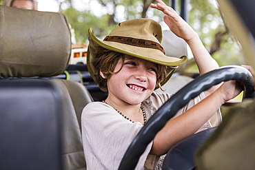 Smiling Six year old boy in the driving seat of a safari vehicle