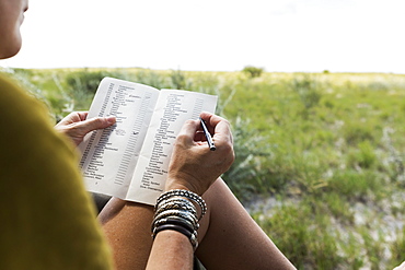 woman writing in safari vehicle, Botswana