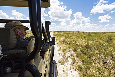 safari guide and vehicle on dirt road