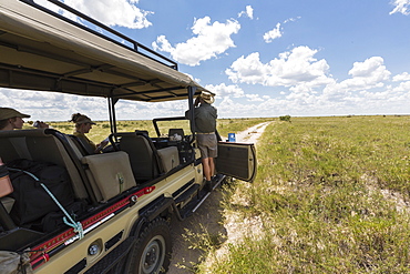 safari guide and vehicle on dirt road