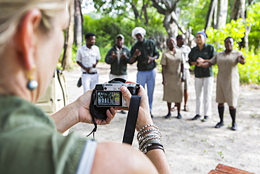 adult woman taking pictures of tented camp staff, Botswana