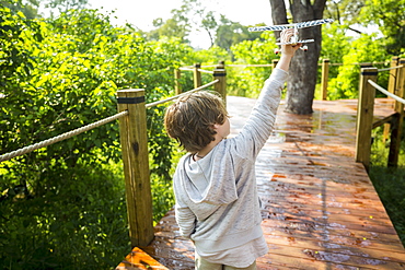 Six year old boy playing with toy airplane, tented camp, Botswana