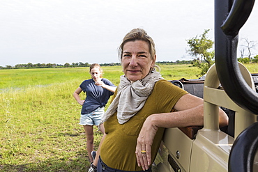 portrait of adult woman leaning on safari vehicle, Botswana