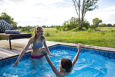 Brother and sister, Two children swimming in small pool at a safari camp, Botswana