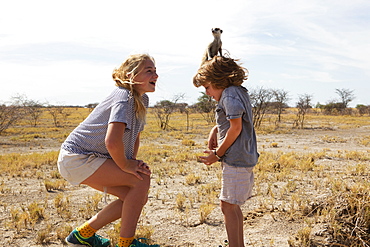 5 year old boy with Meerkat on his head, Kalahari Desert, Makgadikgadi Salt Pans, Botswana