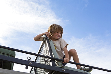 5 year old boy atop safari vehicle, Kalahari Desert, Makgadikgadi Salt Pans, Botswana