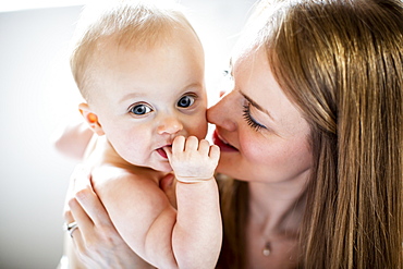 Portrait of baby being held by woman looking at camera