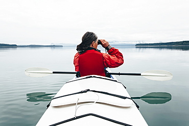 Sea kayakers looking at nautical chart and mapan inlet on the, Alaska coastline