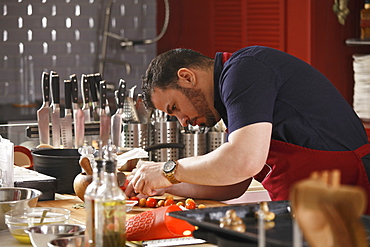 A chef bending and preparing food in a commercial kitchen, Russia