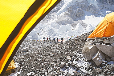 Hikers backpacking on mountain, in a row on a rocky hilltop, Khumbu region, Nepal