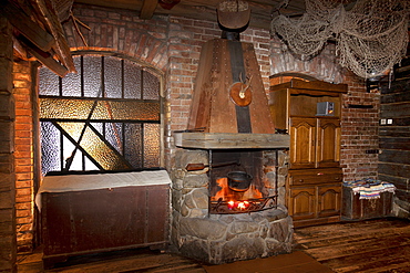 A hotel with old fashioned retro styled rooms, and rustic objects, open lit fire with large stonework chimney and wooden floor, Estonia