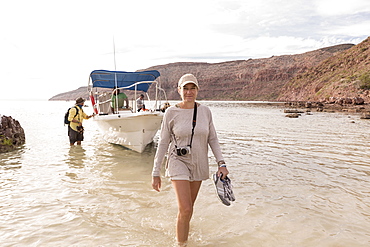 Woman walking to shore from power boat, Sea of Cortes, Mexico