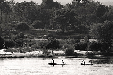 Locals going down the Zambezi River in traditional mokoro canoes, Zambia