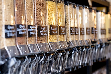 Close up of food dispensers with dried pasta in a waste free wholefood store, Watlington, Oxfordshire, United Kingdom