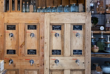 Close up of wooden dispensers for cleaning products in a waste free wholefood store, Watlington, Oxfordshire, United Kingdom