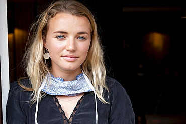 Portrait of young blond woman wearing face mask around her neck, smiling at camera, Watlington, Oxfordshire, United Kingdom