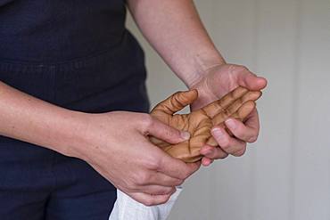 Therapist touching a client's hands