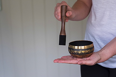 female therapist using Tibetan singing bowl, sound therapy