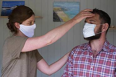 Therapist and client in face masks, in an alternative therapy session