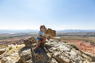 Boy hiking to the top of Chimney Rock landmark in a protected canyon landscape, New Mexico, United States of America