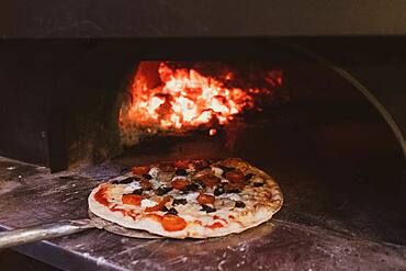 Close up of pizza in a wood-fired oven in a restaurant