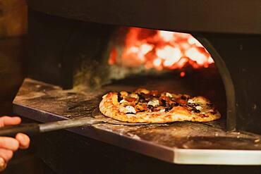 Close up of pizza in a wood-fired oven in a restaurant