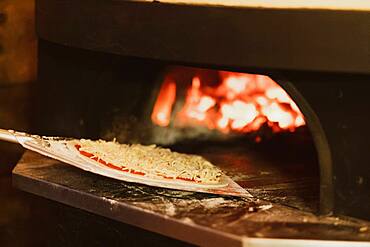 Close up of pizza in a wood-fired oven in a restaurant