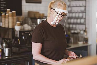 Waitress wearing face mask working in a cafe